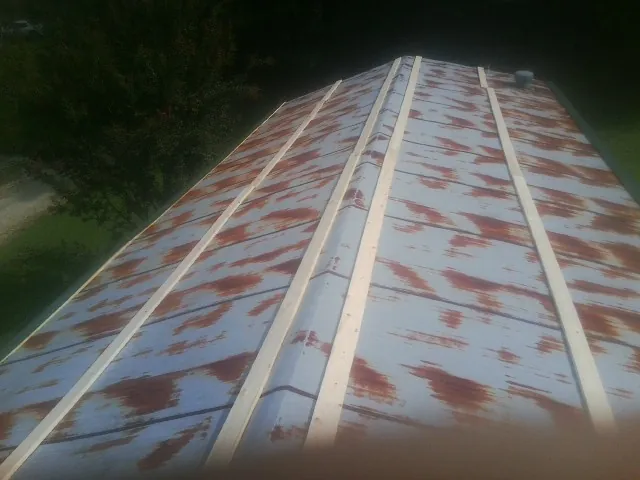 Rusted metal roof panels with new wood purlins before replacement — Storm Damage Roof Repair in Low Moor by Roofing Brothers