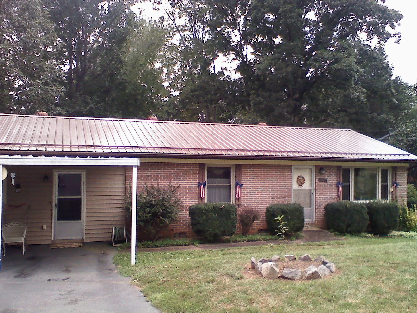 Bronze metal roof and carport on a brick ranch home — Roof Repair work by our crew in Low Moor